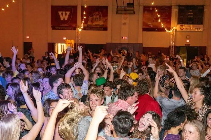 A crowded room dancing under string lights